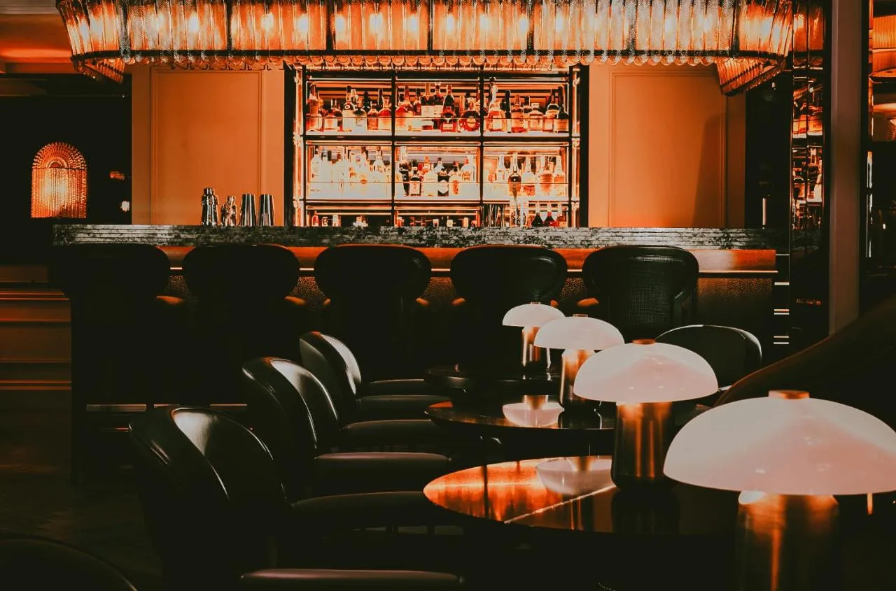 A bar with black chairs and a bar counter at The Mayfair Townhouse in London