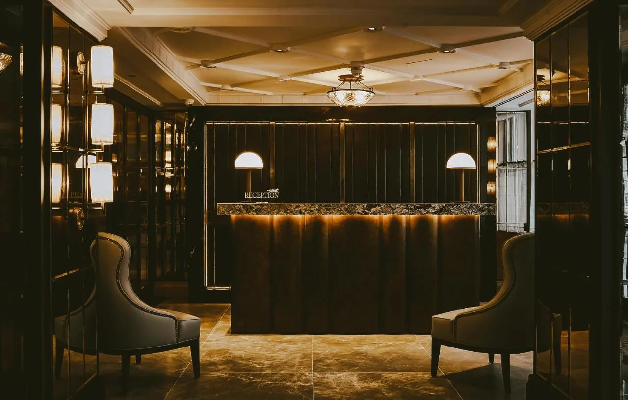 A bar in a black room with two chairs at The Mayfair Townhouse in London