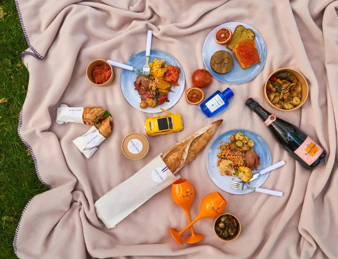 A table with plates of food on a blanket at The Mayfair Townhouse in London